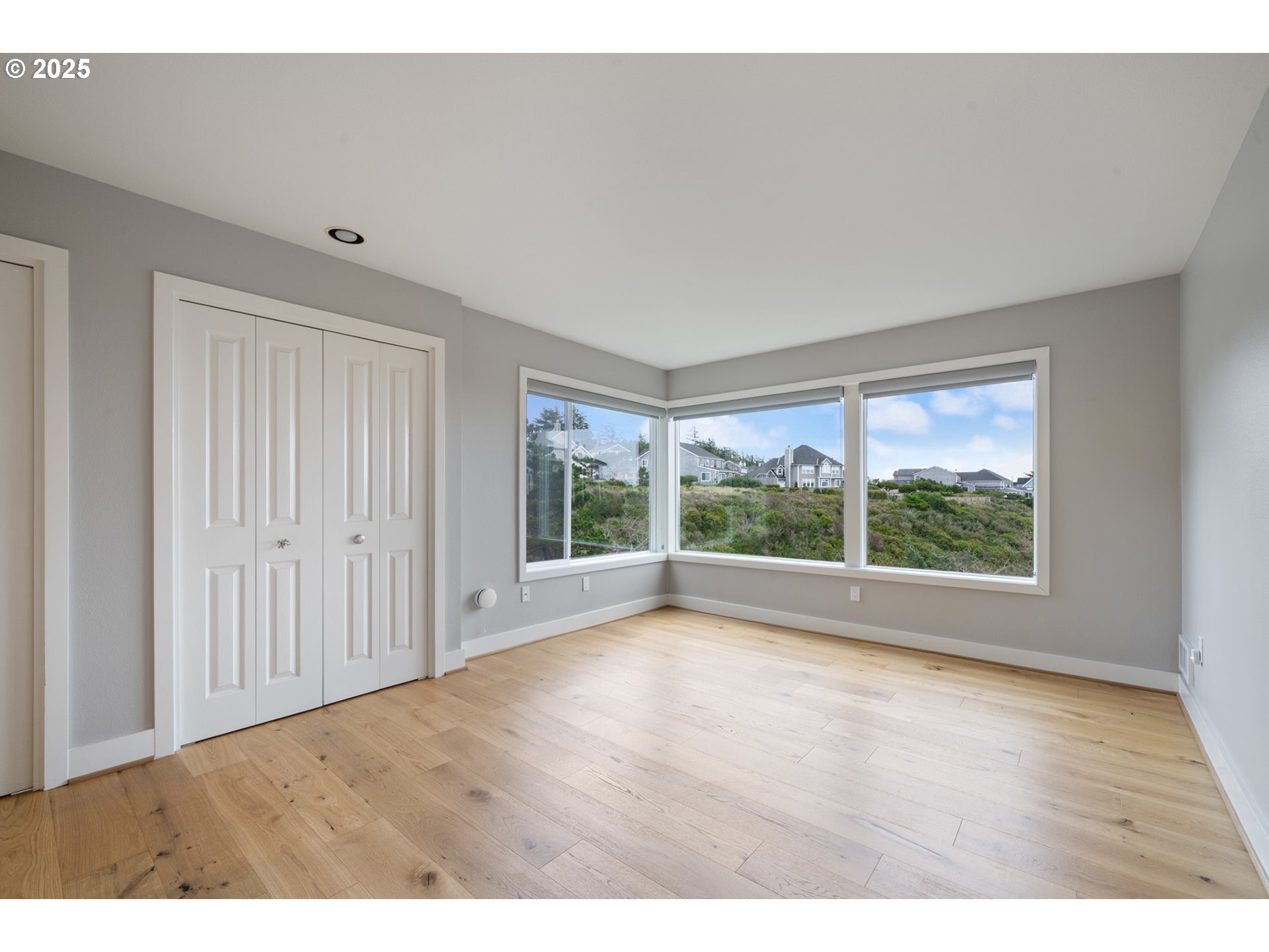 455 Capes Drive Oceanside, OR 97141 - Photo 26 of 48 a view of empty room with wooden floor and fan