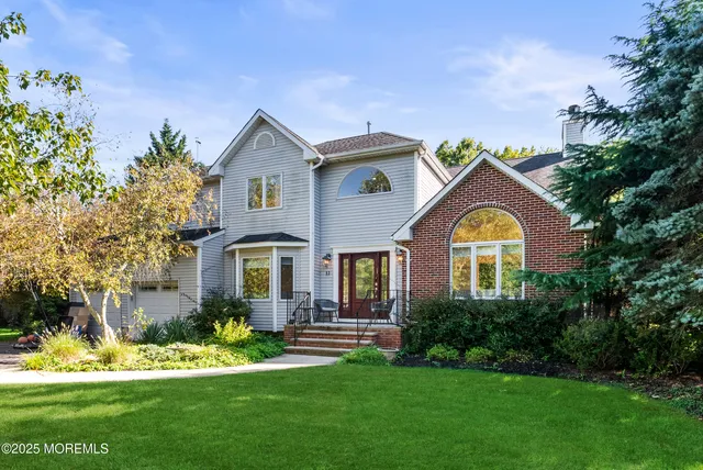 a front view of a house with a garden and plants