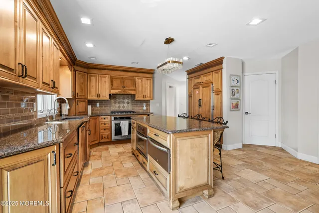a kitchen with stainless steel appliances granite countertop a stove top oven a sink dishwasher and a refrigerator