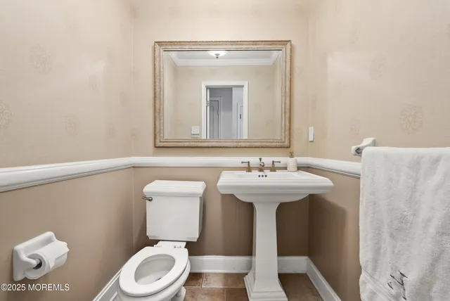 a bathroom with a toilet a sink and mirror
