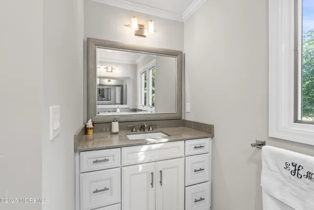 a bathroom with a granite countertop sink vanity and mirror
