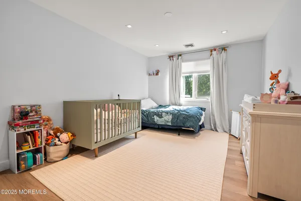 a view of a bedroom with baby bed and a window