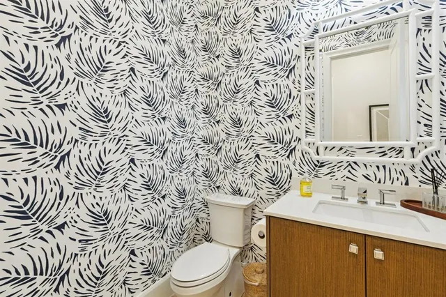 a bathroom with a granite countertop sink and a toilet