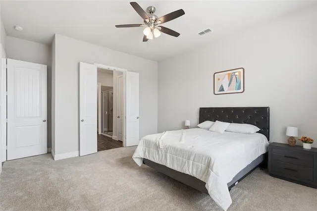 a bedroom with a bed and a ceiling fan