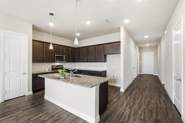 a kitchen with a stove a refrigerator and a microwave