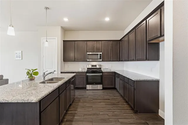 a kitchen with kitchen island granite countertop wooden cabinets and stainless steel appliances