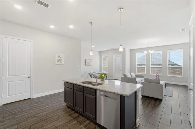 a kitchen with center island table and a living room