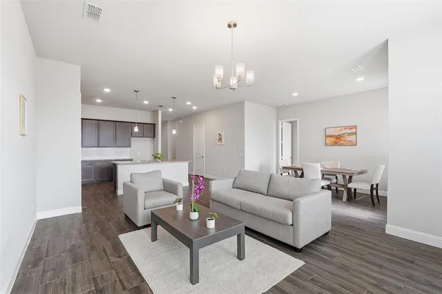 a living room with furniture and kitchen view