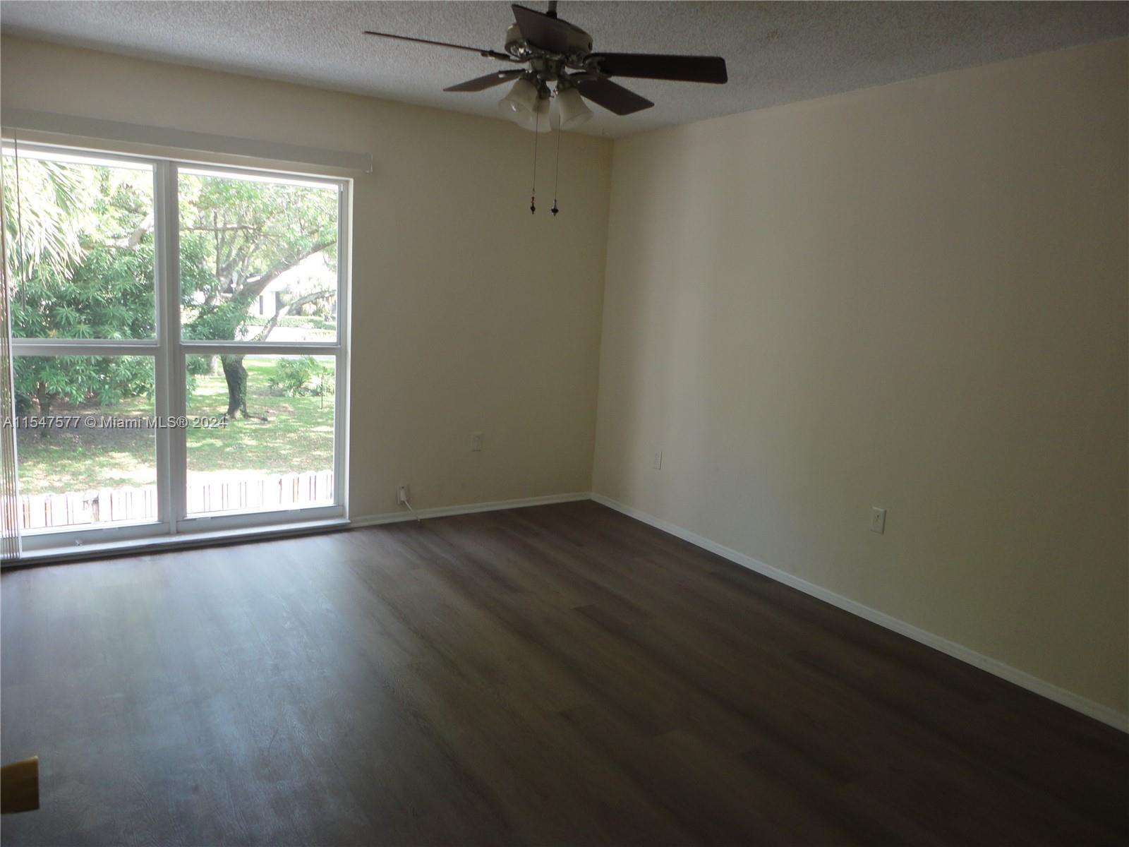 3321 Raleigh Street, Unit 3H Hollywood, FL 33021 - Photo 18 of 38 an empty room with wooden floor fan and windows