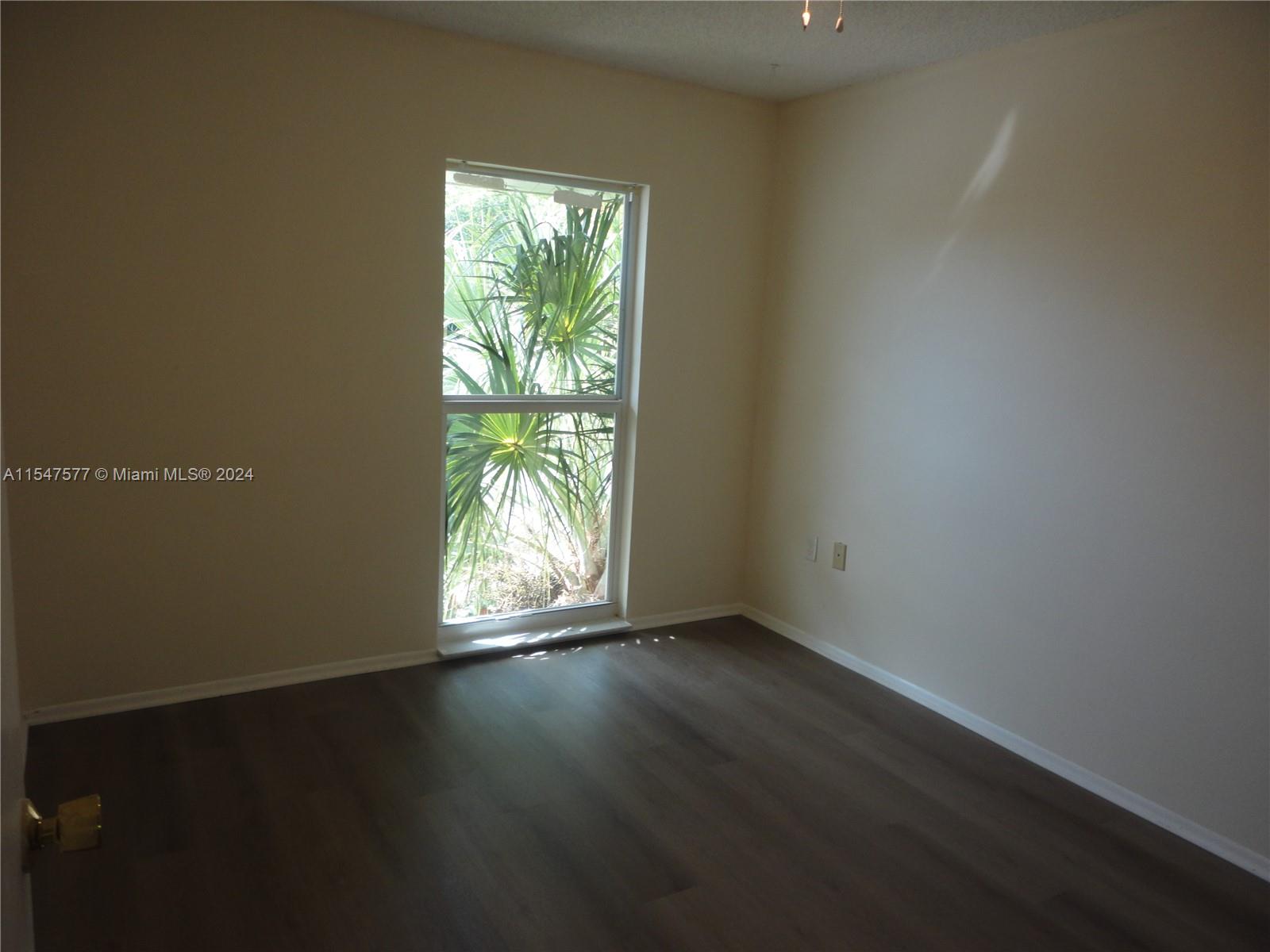 3321 Raleigh Street, Unit 3H Hollywood, FL 33021 - Photo 30 of 38 a view of an empty room with wooden floor and a window
