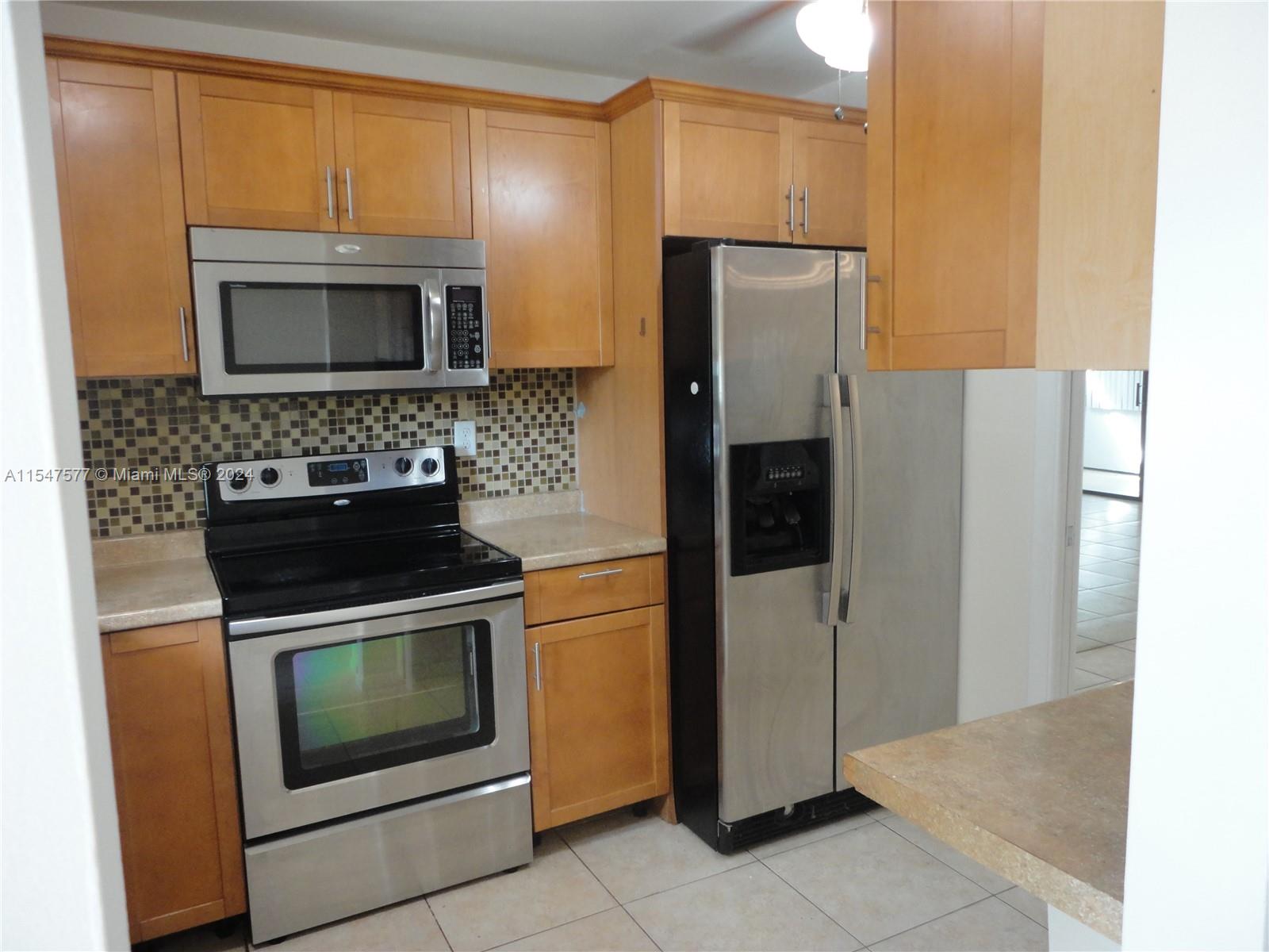 3321 Raleigh Street, Unit 3H Hollywood, FL 33021 - Photo 4 of 38 a kitchen with a refrigerator stove and microwave