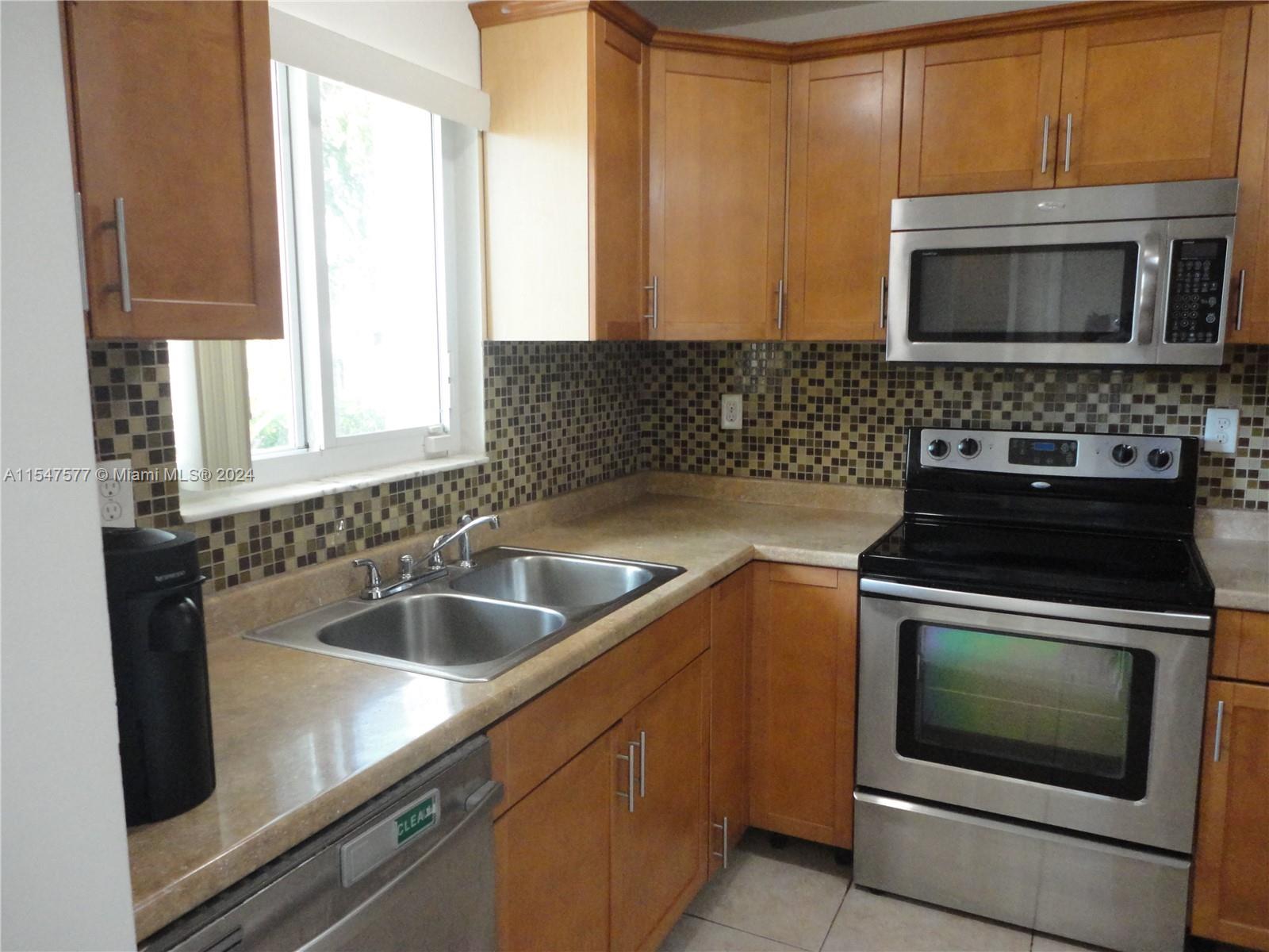 3321 Raleigh Street, Unit 3H Hollywood, FL 33021 - Photo 5 of 38 a kitchen with a sink stove and microwave