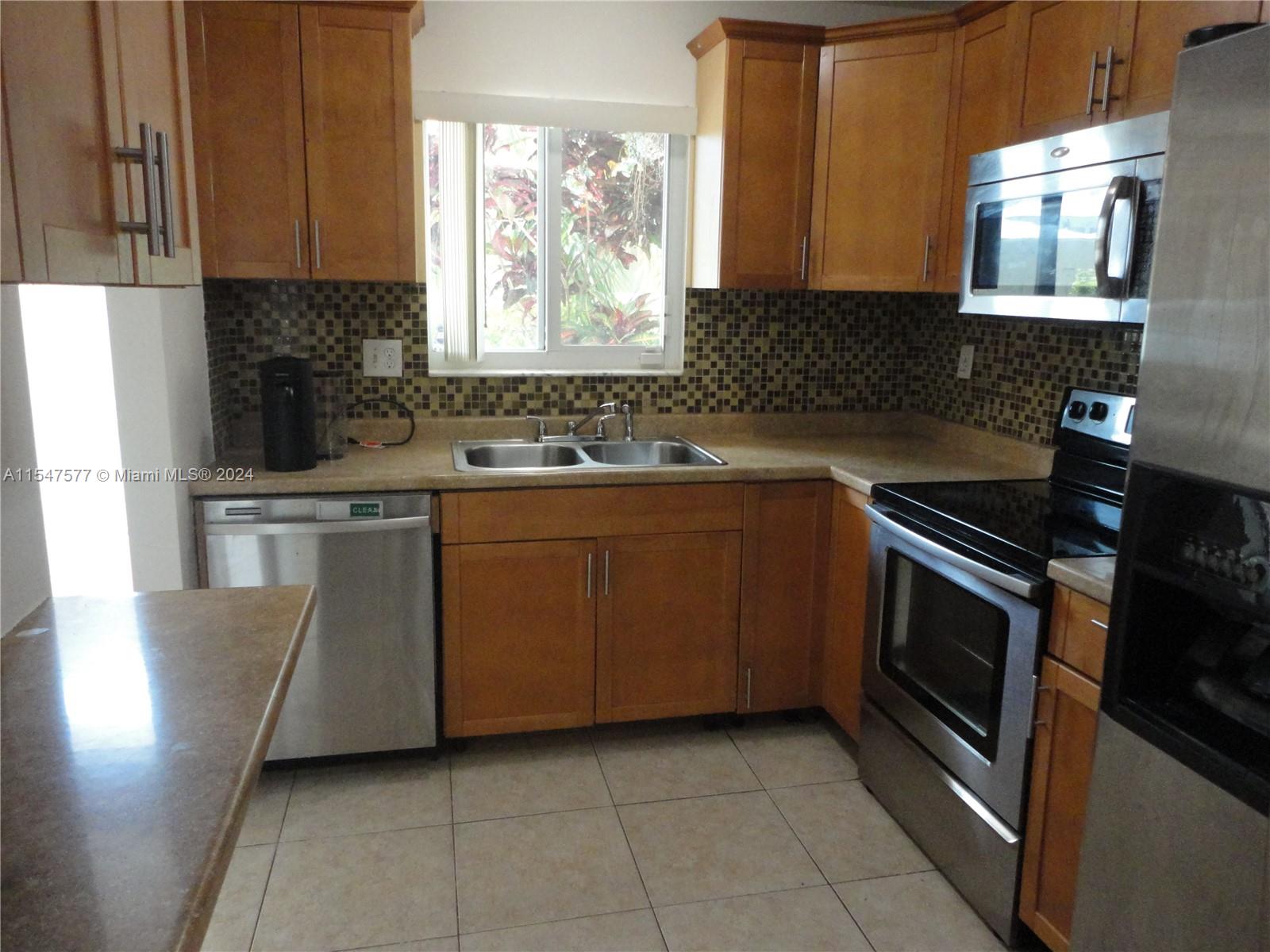 3321 Raleigh Street, Unit 3H Hollywood, FL 33021 - Photo 6 of 38 a kitchen with a stove a sink and a microwave