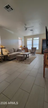 a living room with stainless steel appliances granite countertop a couch and a stove top oven