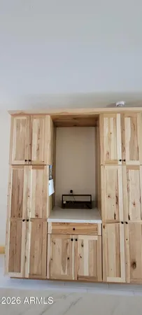 a utility room with stainless steel appliances wooden cabinet and a view of staircase