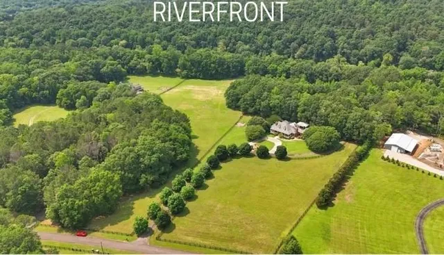 an aerial view of a residential houses with outdoor space and trees