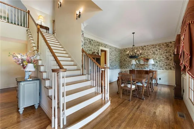 a kitchen with stainless steel appliances granite countertop a stove top oven a sink a dining table and chairs with wooden floor