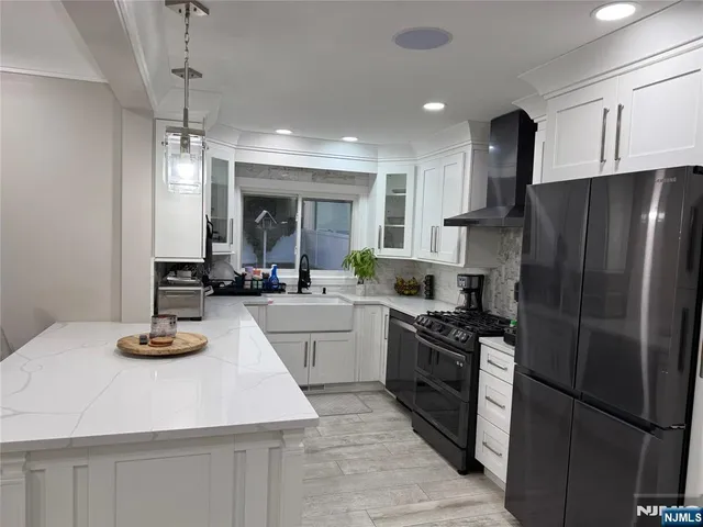 a kitchen with kitchen island a counter top space a sink cabinets and stainless steel appliances