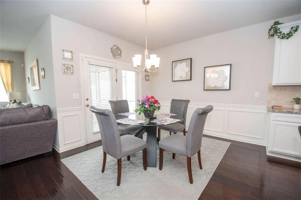 531 Carleton Place Locust Grove, GA 30248 - Photo 17 of 41 a dining room with furniture a chandelier and wooden floor