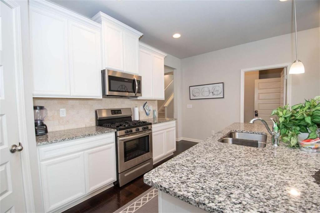 531 Carleton Place Locust Grove, GA 30248 - Photo 20 of 41 a kitchen with granite countertop cabinets stainless steel appliances and a potted plant