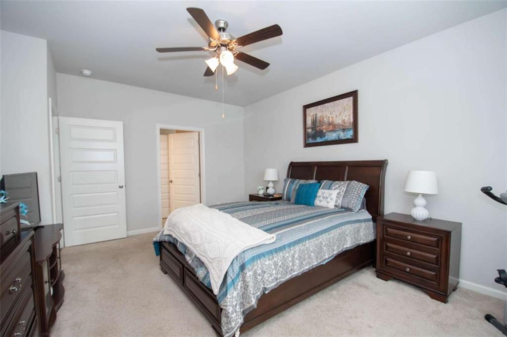 531 Carleton Place Locust Grove, GA 30248 - Photo 26 of 41 a bedroom with a bed and a chandelier