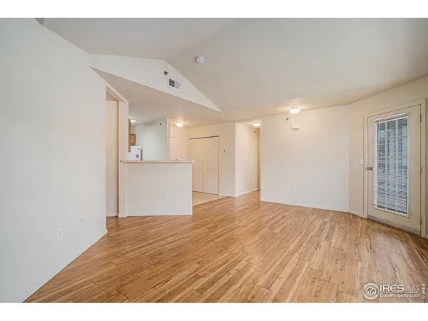 a view of an empty room with wooden floor