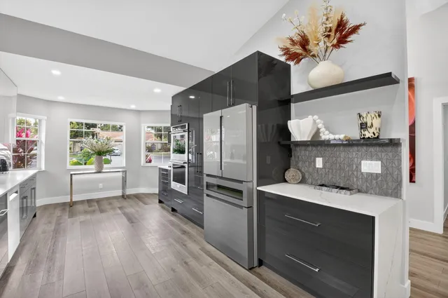 a kitchen with stainless steel appliances a sink wooden floor and cabinets