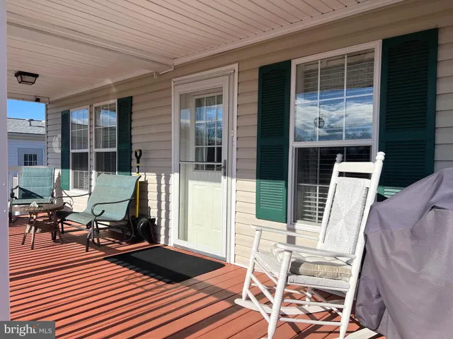 a view of a patio with table and chairs with wooden floor and fence