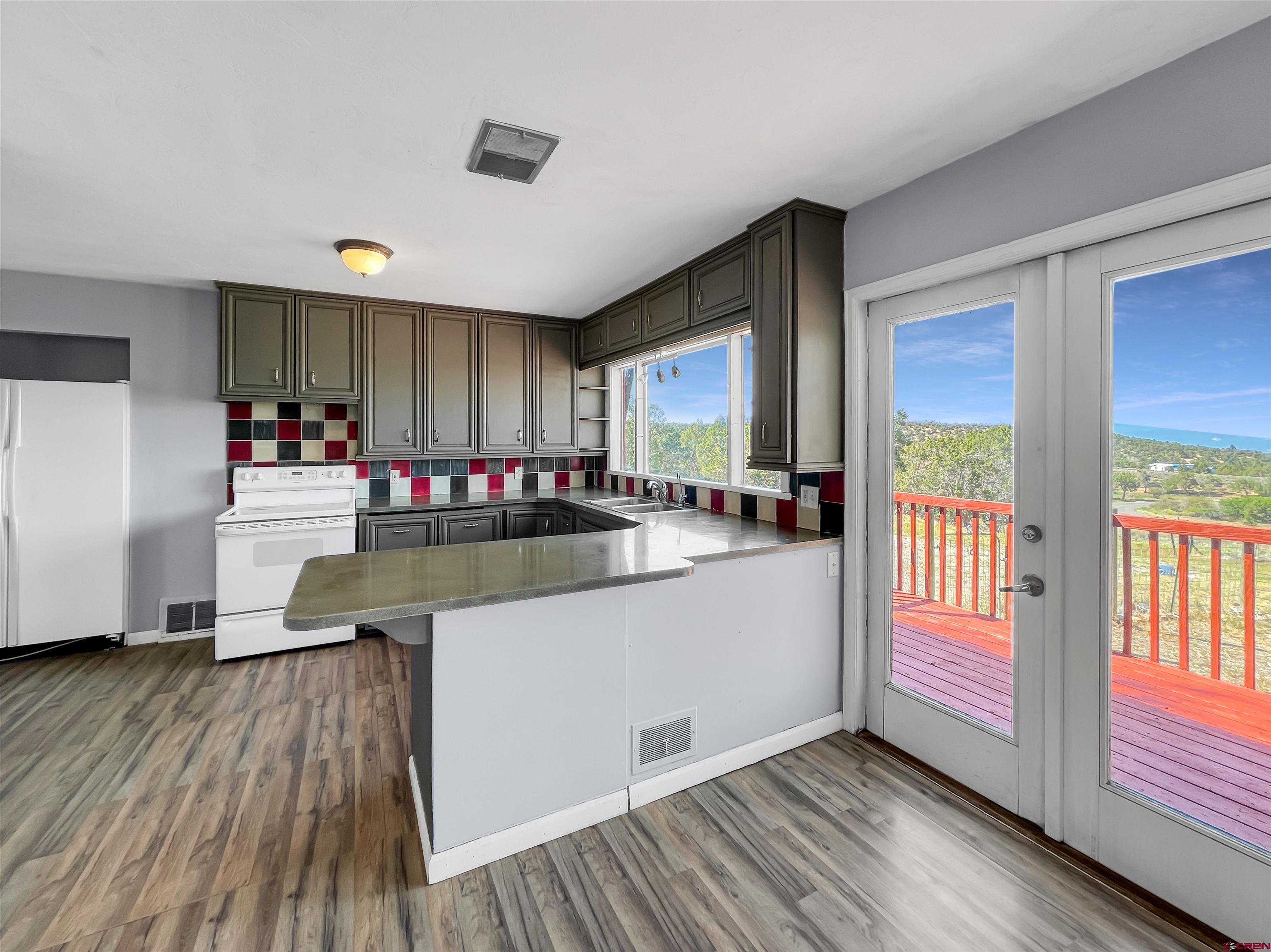 2001 Black Canyon Road Crawford, CO 81415 - Photo 13 of 45 a kitchen with granite countertop a stove and wooden floor