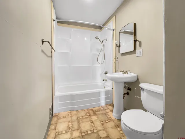 a bathroom with a toilet and a shower
