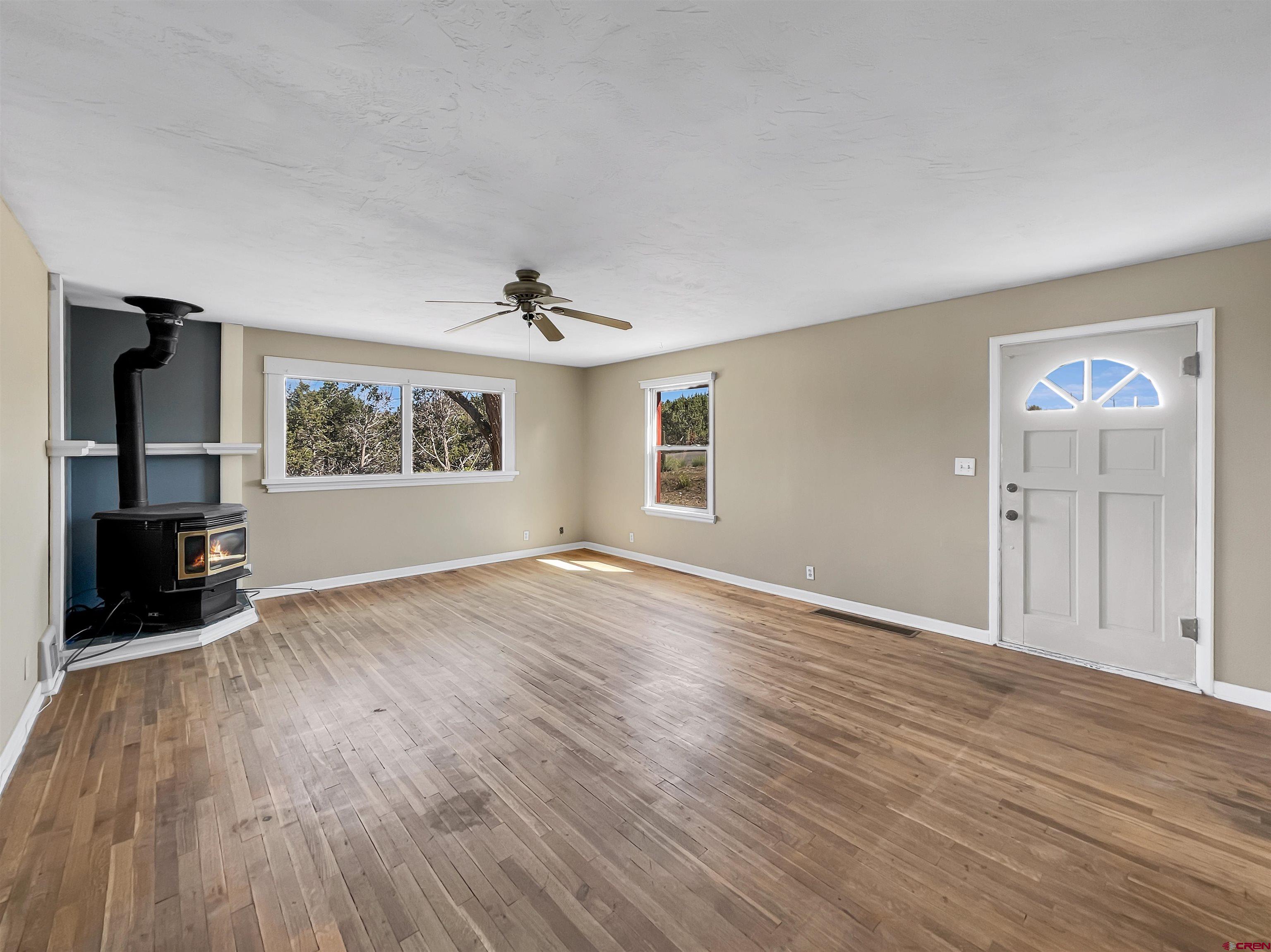 2001 Black Canyon Road Crawford, CO 81415 - Photo 5 of 45 a view of empty room with wooden floor and fireplace