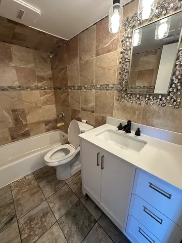 a bathroom with a sink toilet a mirror and bathtub