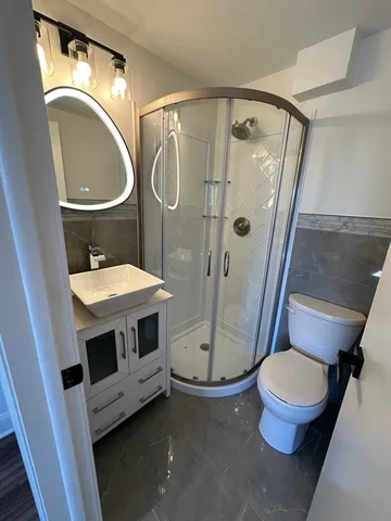 a bathroom with a granite countertop toilet and a sink