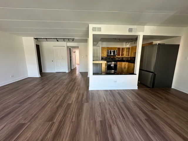 a view of a room with wooden floor and a window