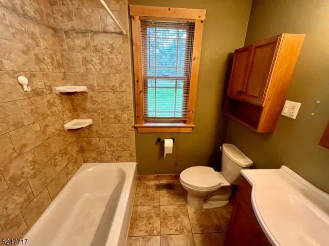 a bathroom with a granite countertop toilet and a sink