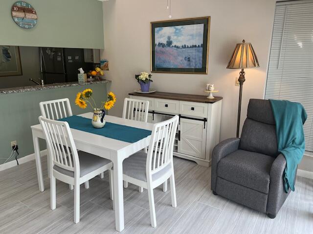 1605 Highway 1, Unit 201M2 Jupiter, FL 33477 - Photo 2 of 47 a view of a dining room with furniture and wooden floor