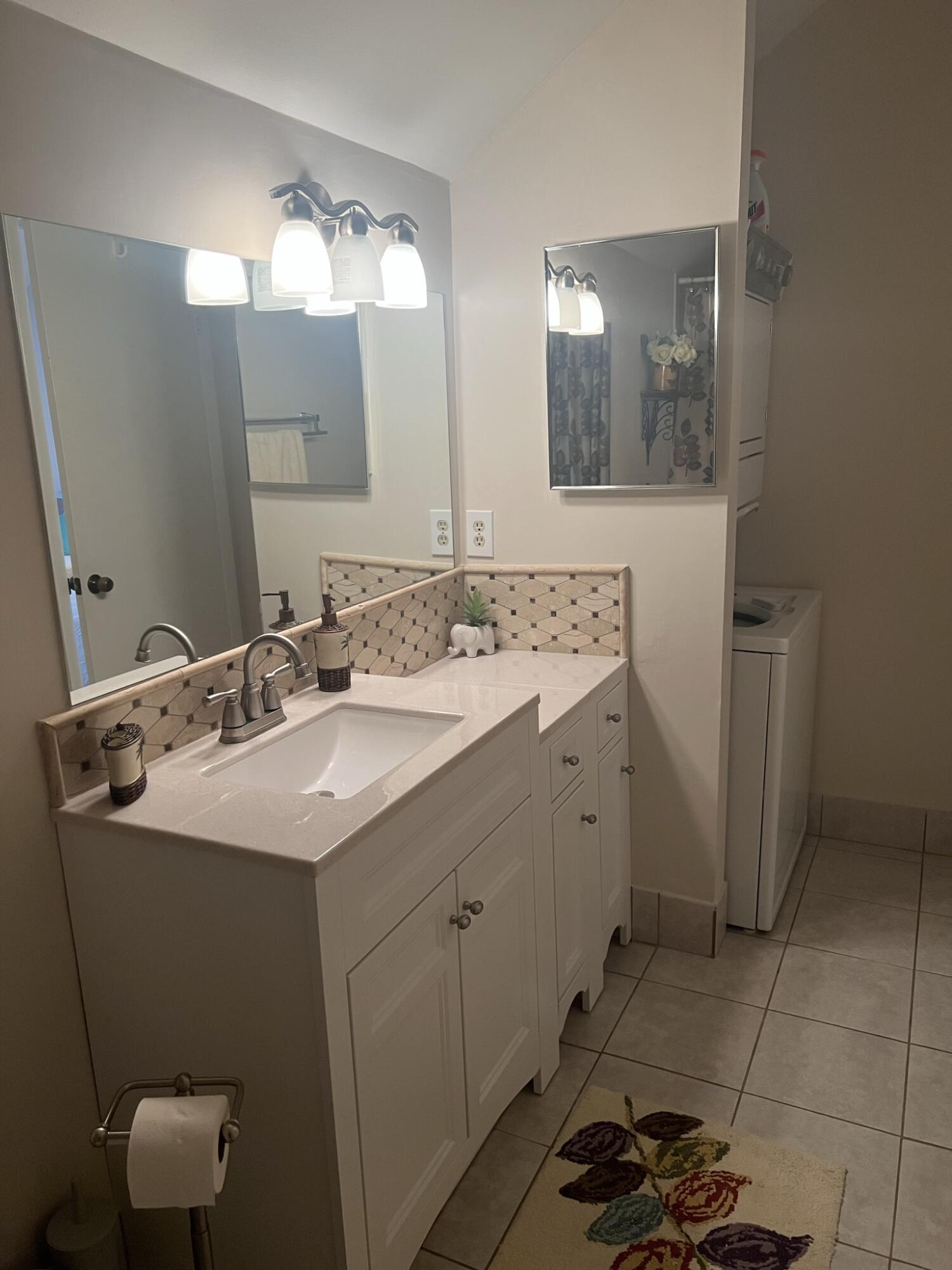 1605 Highway 1, Unit 201M2 Jupiter, FL 33477 - Photo 26 of 47 a bathroom with a sink and a mirror
