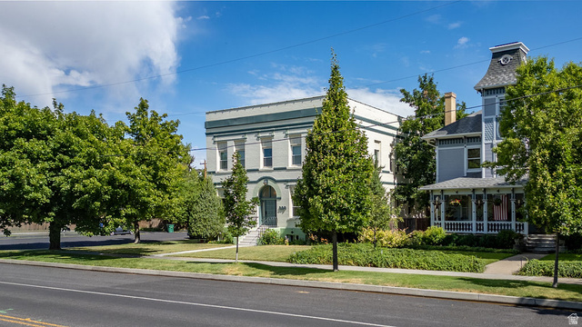 299 West Center Street, Unit 2 Logan, UT 84321 - Photo 36 of 46 Historic-style building featuring a light green facade with white trim, arched entryway, and multiple windows