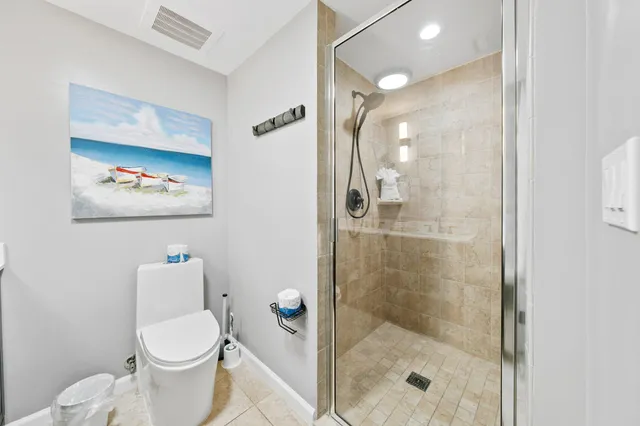 a bedroom with a bed and a potted plant on the dresser