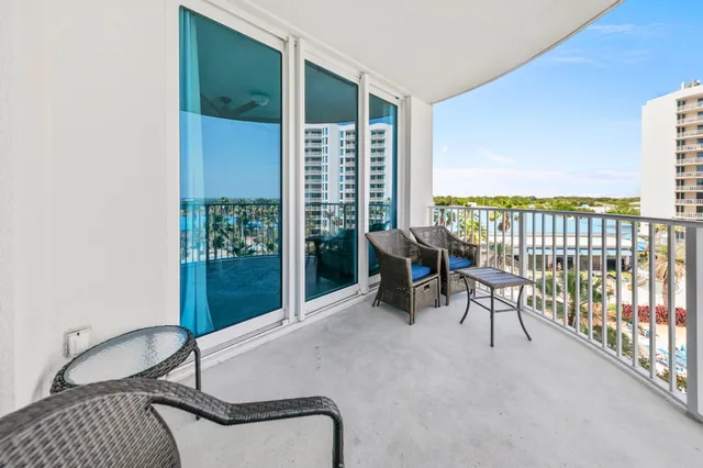 a balcony with chairs and a potted plant