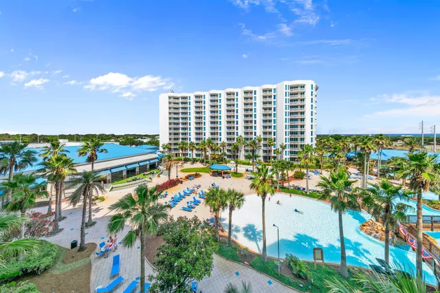 a living room with stainless steel appliances kitchen island granite countertop swimming pool and a large window