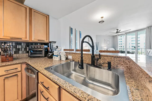 a kitchen with granite countertop a sink and a stove top oven