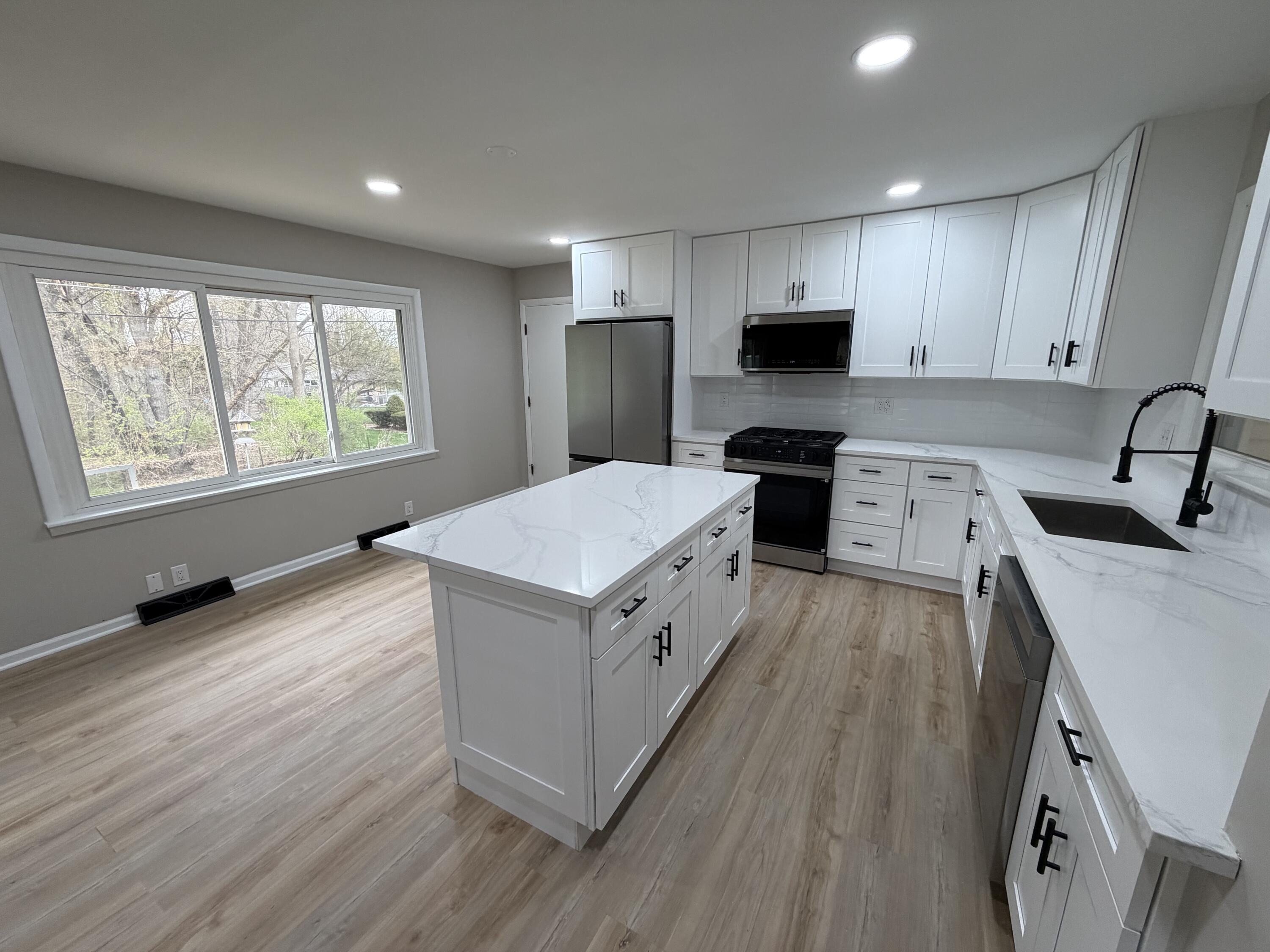 603 West 13th Street La Porte, IN 46350 - Photo 3 of 18 a kitchen with a stove a sink a microwave and wooden floor