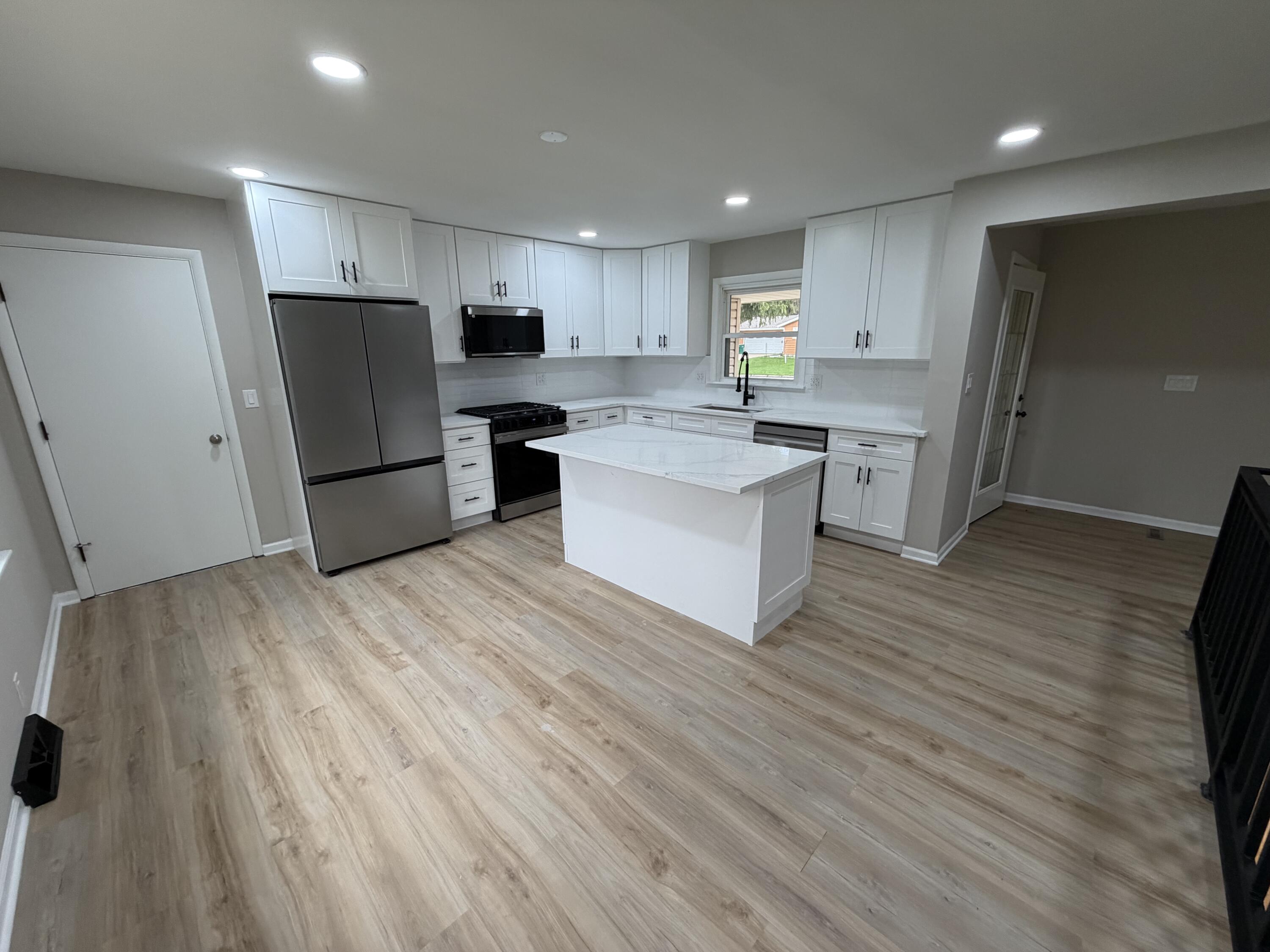 603 West 13th Street La Porte, IN 46350 - Photo 4 of 18 a kitchen with stainless steel appliances refrigerator sink cabinets and wooden floor