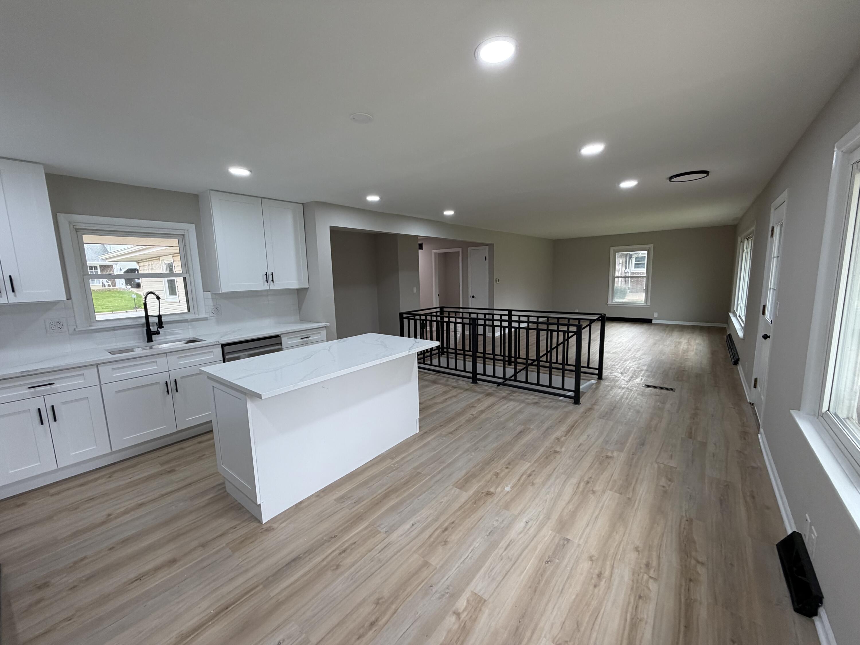 603 West 13th Street La Porte, IN 46350 - Photo 6 of 18 a large white kitchen with wooden floors and stainless steel appliances