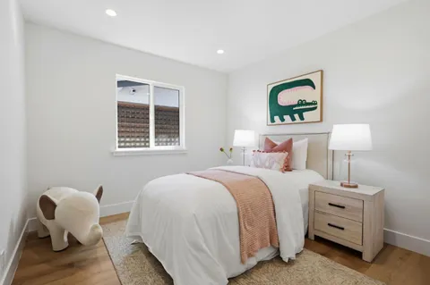 a bedroom with bed and a painting on the wall