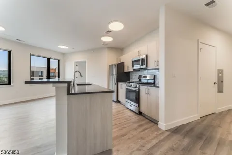 a kitchen with stainless steel appliances granite countertop a refrigerator sink and stove