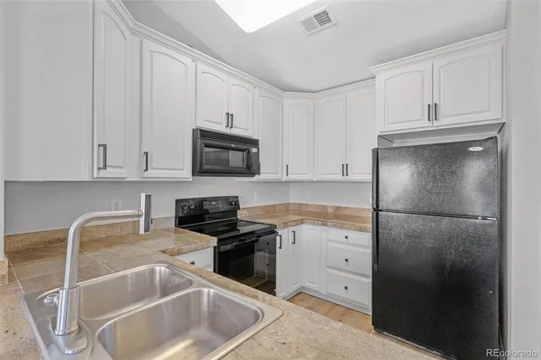 a kitchen with white cabinets and stainless steel appliances
