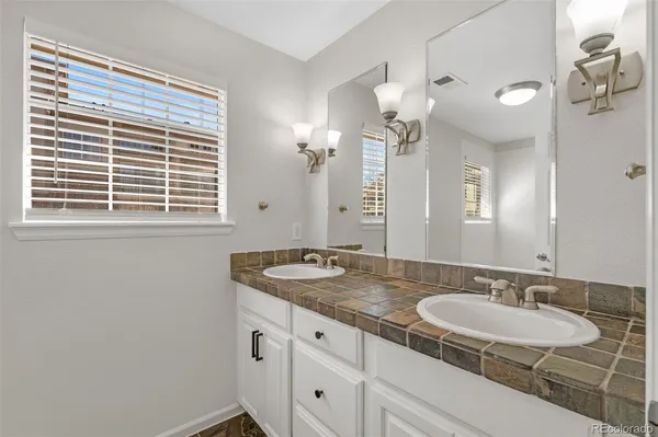 a bathroom with a granite countertop sink and a mirror