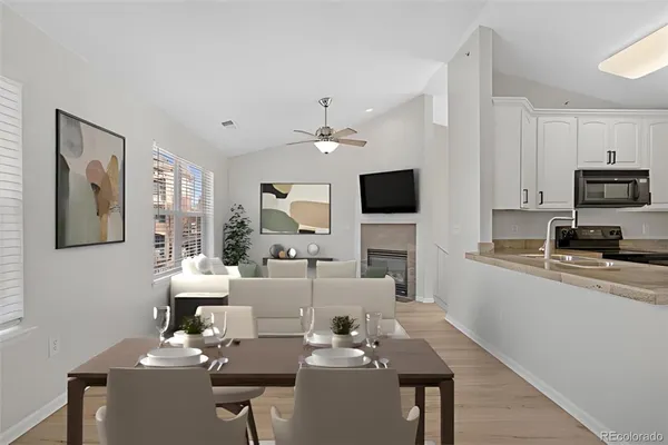 a living room with furniture a flat screen tv and kitchen view